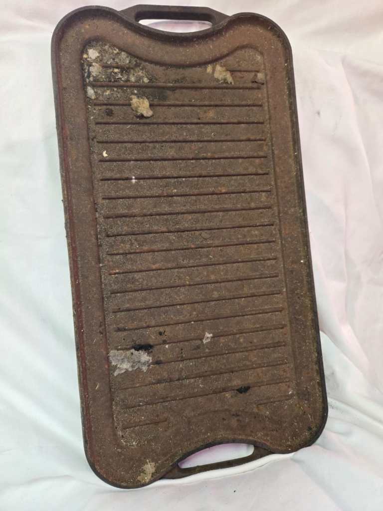Cast iron, 2-sided, double-burner grill pan, rusted and dirty.